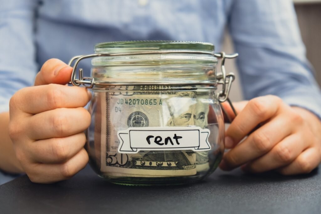 Receipt for rent payment concept showing cash saved in a labeled rent jar, representing monthly rent budgeting and documented rental payments.